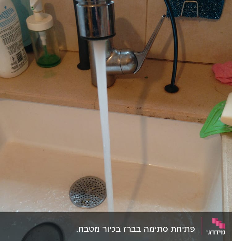 ברז מטבח עם מים זורמים לכיור